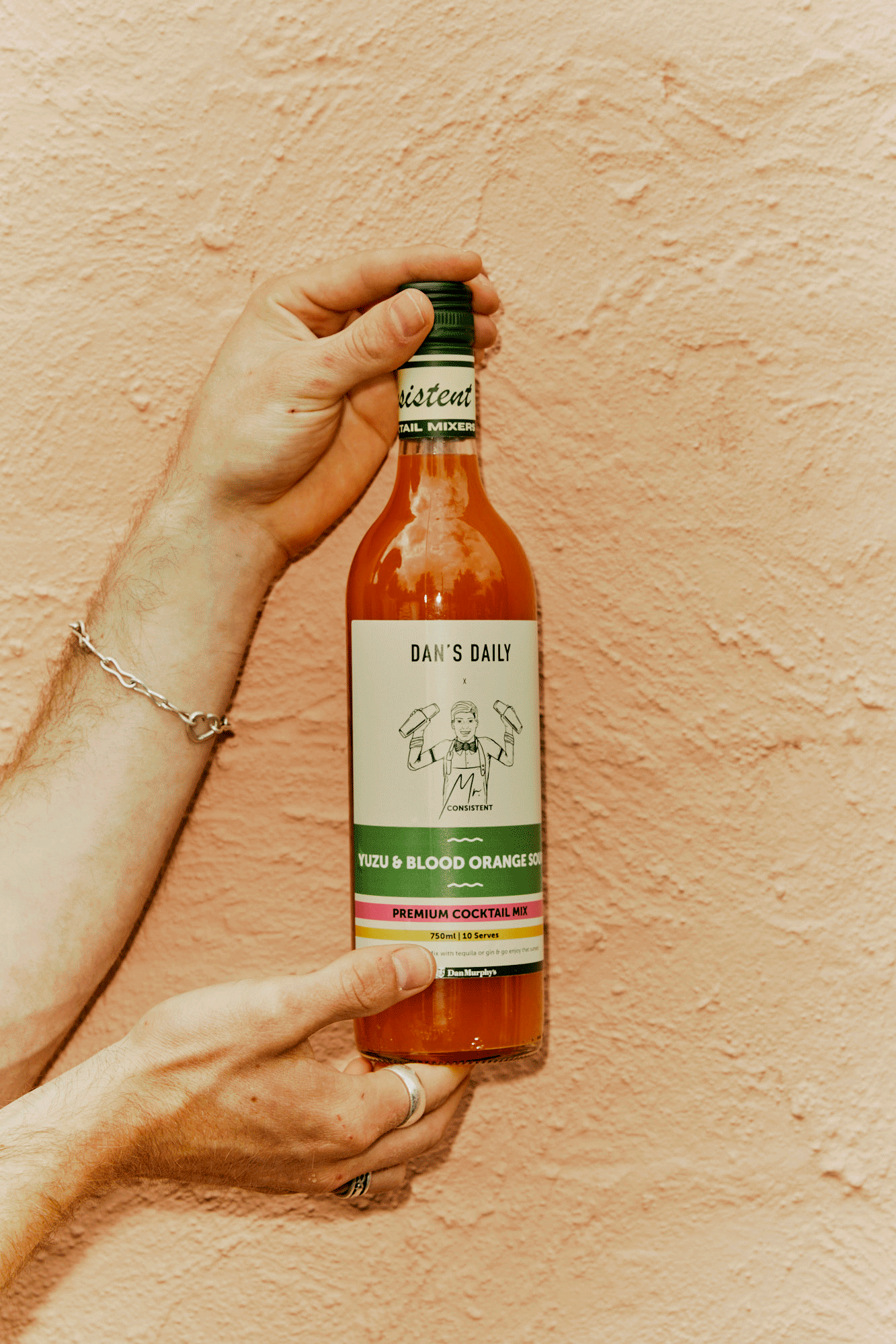 Dan's Daily x Mr. Consistent Yuzu & Blood Orange Sour cocktail mixer spinning in man's hands