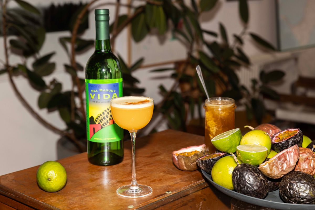 Crimes of Passion cocktail and bottle of Del Vida Maguey Mezcal