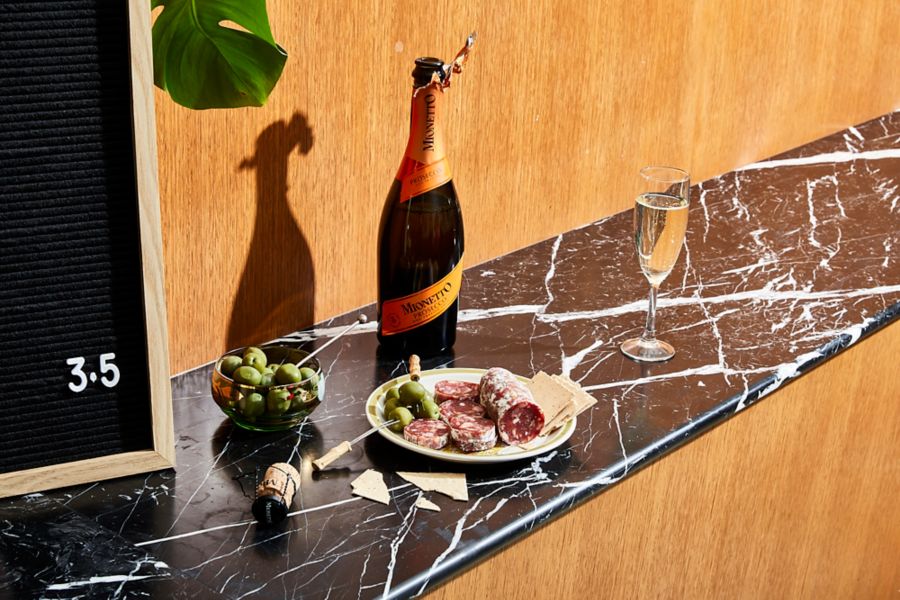Salami on a plate with a bottle of prosecco 