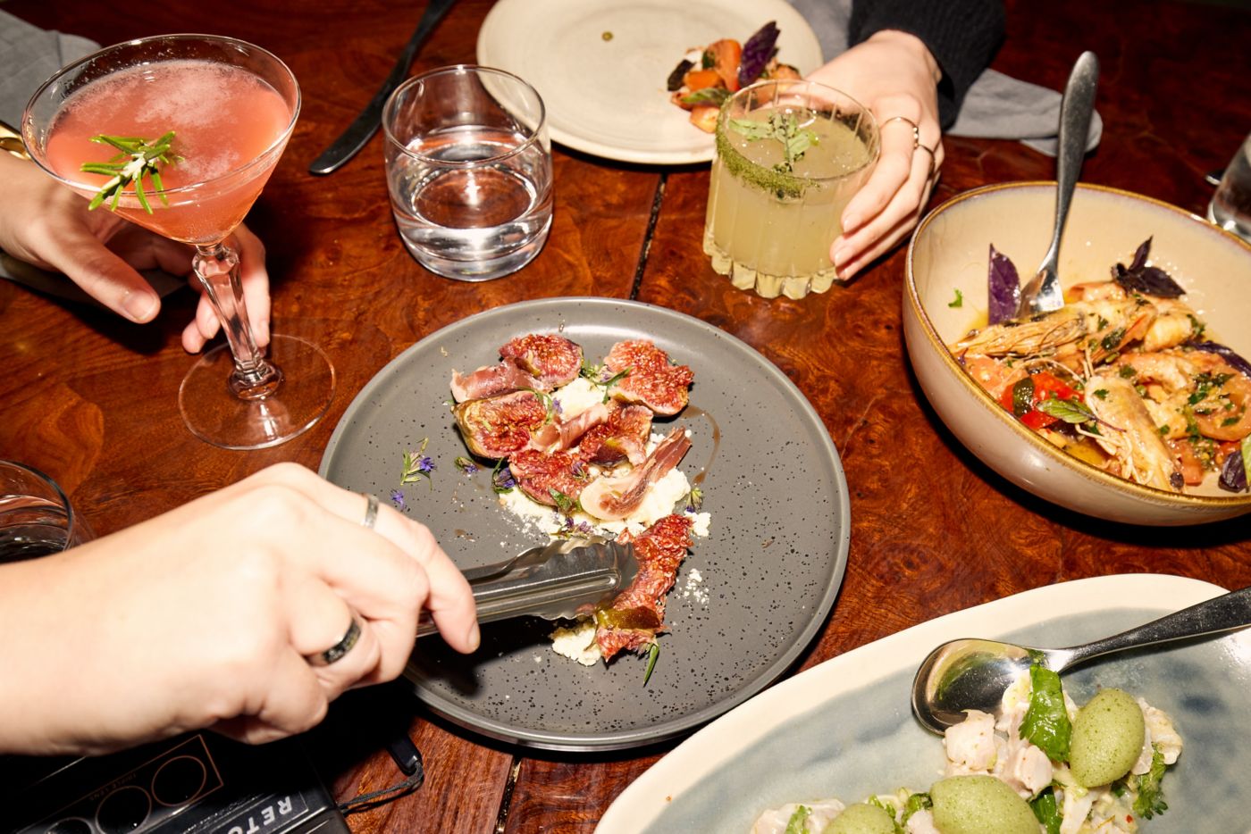Various share plates of food and drinks on a table