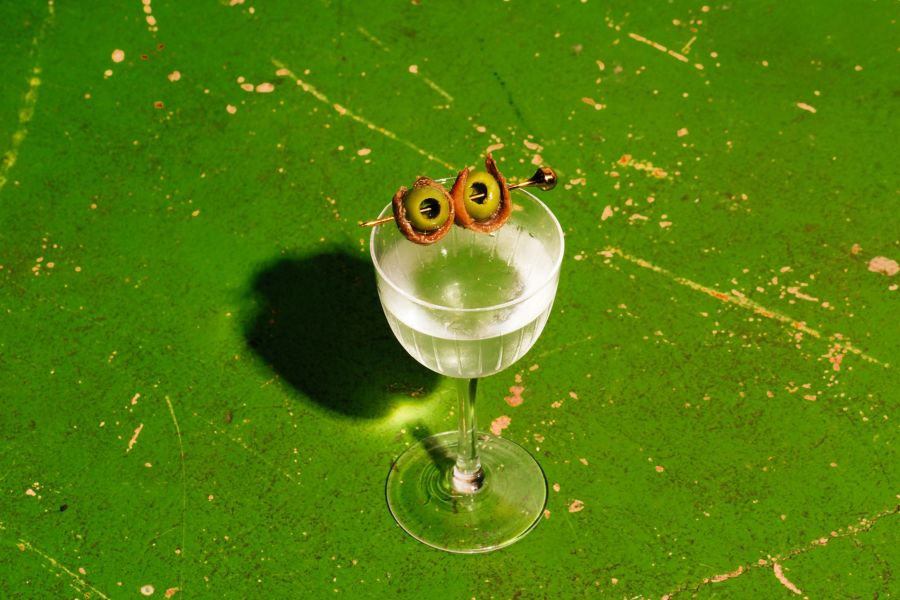 Skewered olives and anchovies garnish a Dirty Martini