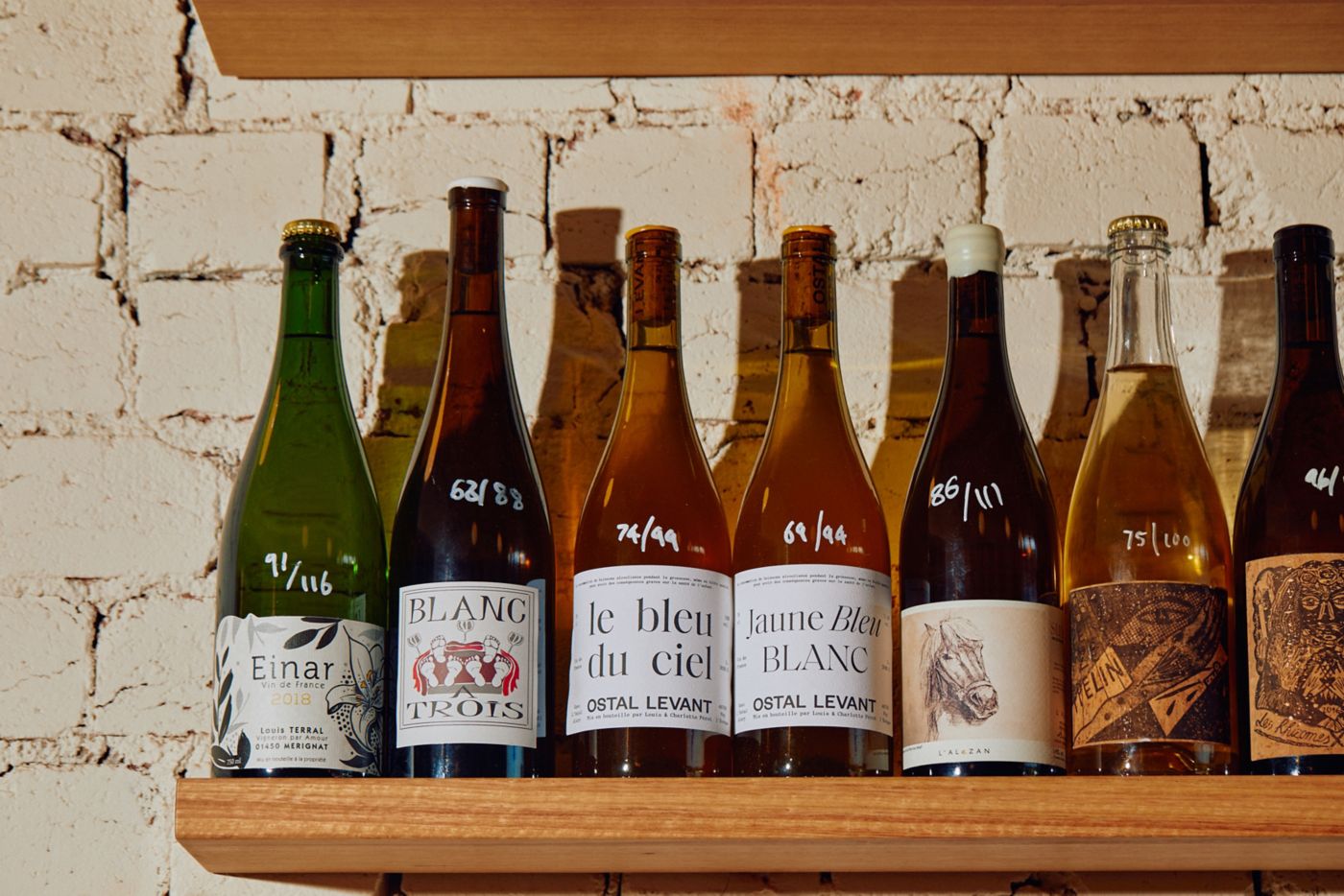 Bottles of wine lined up on a shelf in a bar