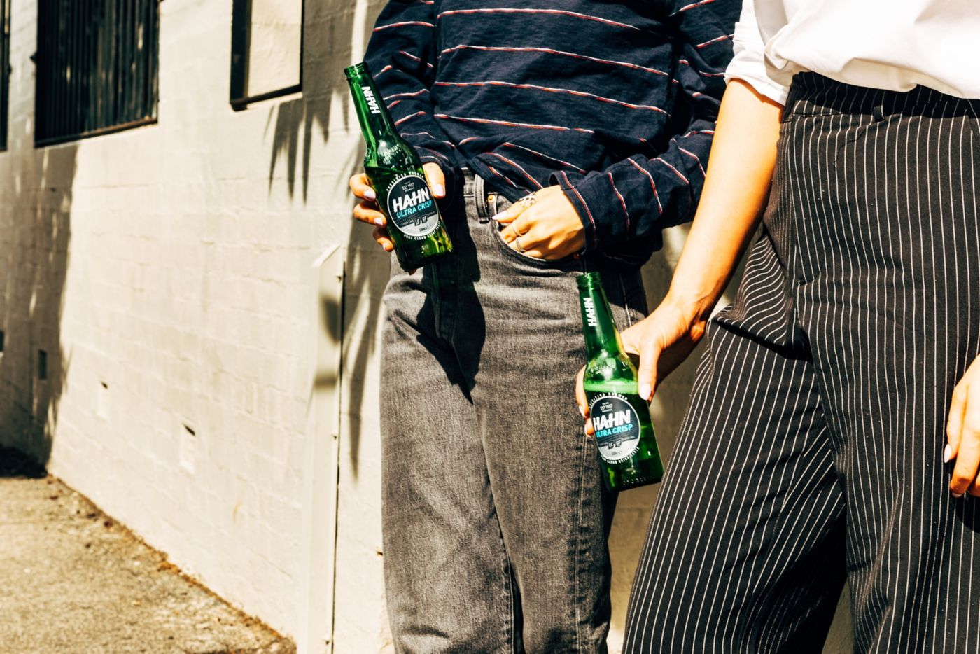 People holding a bottle of Hahn Ultra Crisp gluten-free beer