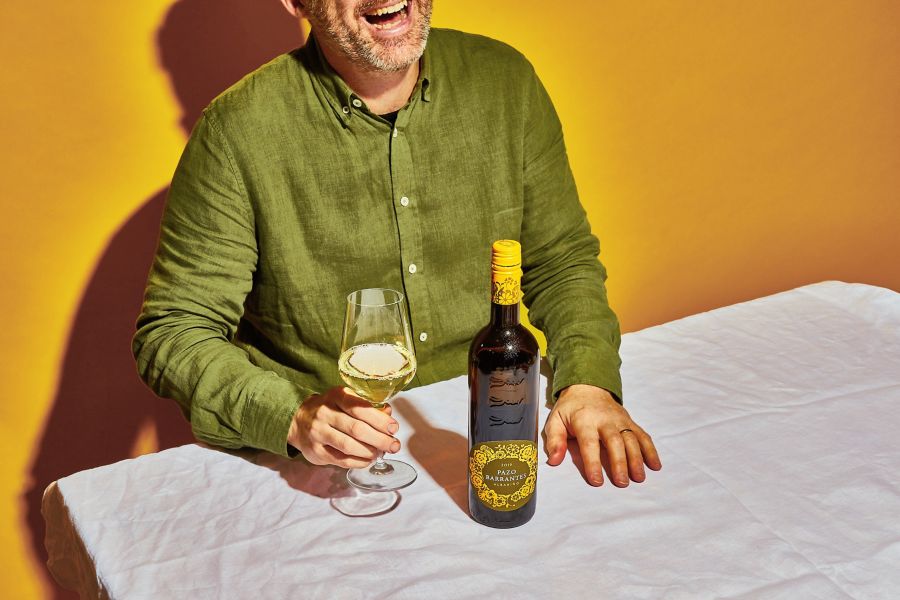 A man laughing with a glass of the Rias Baixas albariño