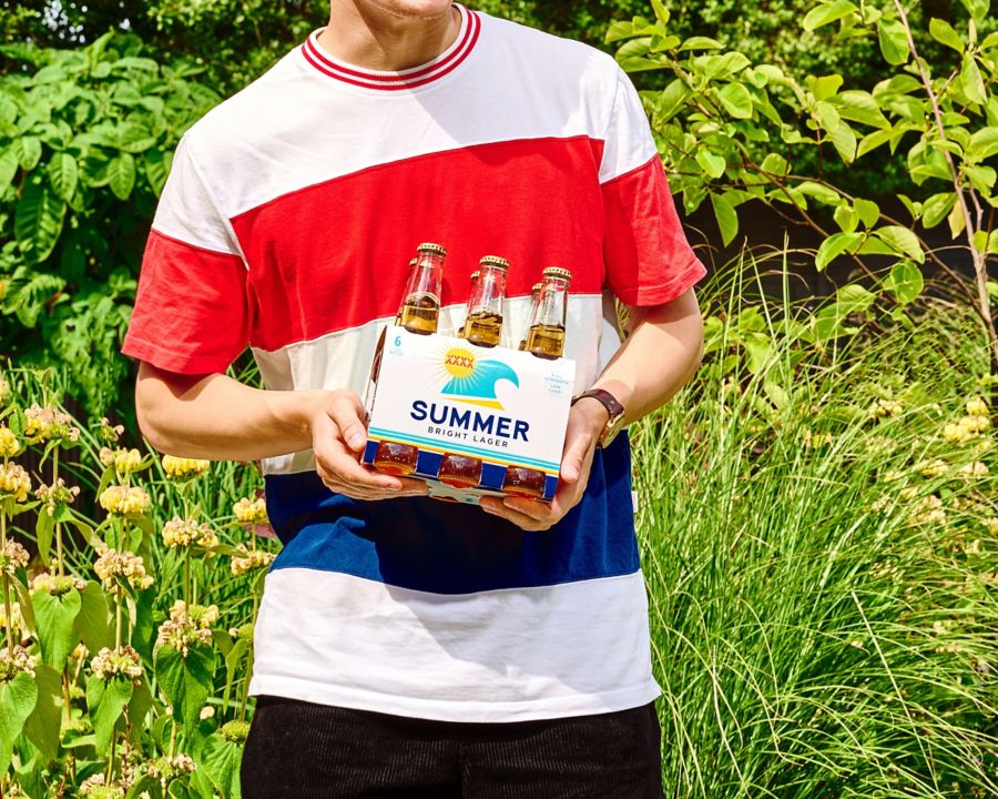Holding a six-pack of XXXX Summer Bright