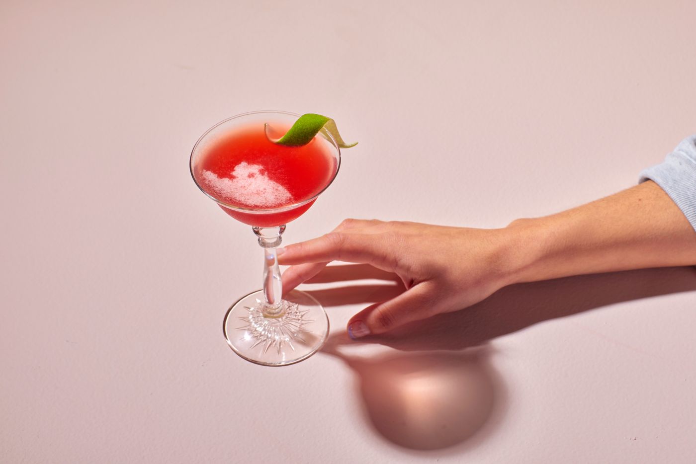 Reaching for the bright red Charlie Chaplin cocktail  