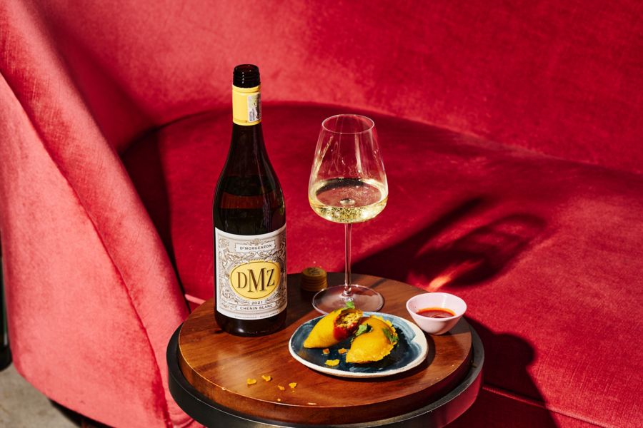 The DMZ Chenin Blanc with a plate of food 