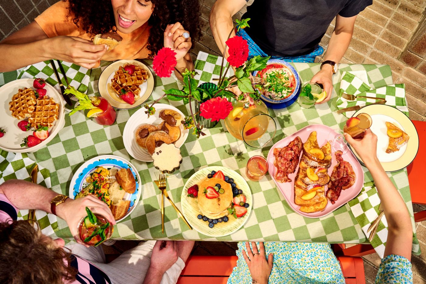 Friends enjoying brunch dishes and drinks at a table together