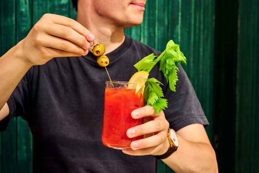 Holding a Bloody Mary cockail 