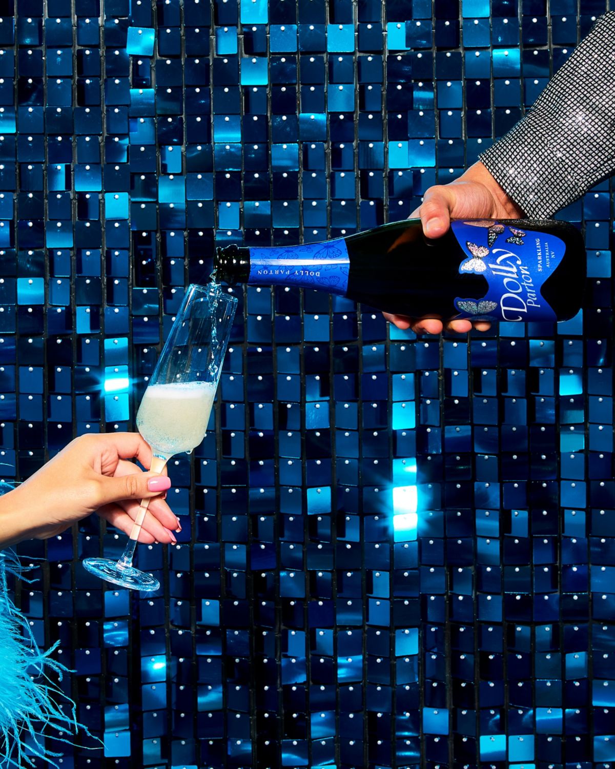 Hand pouring Dolly Parton Wines Sparkling NV into Champagne flute