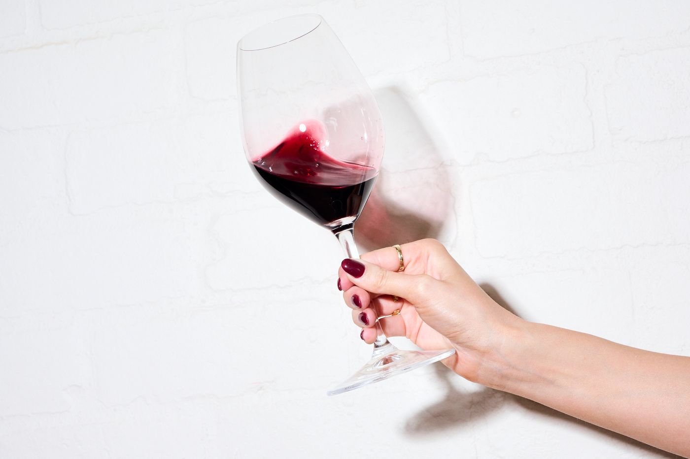 Swirling a.glass of shiraz against a white background 