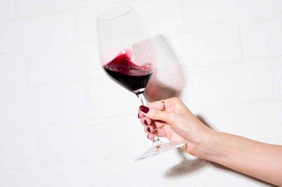 Holding a glass of red wine 