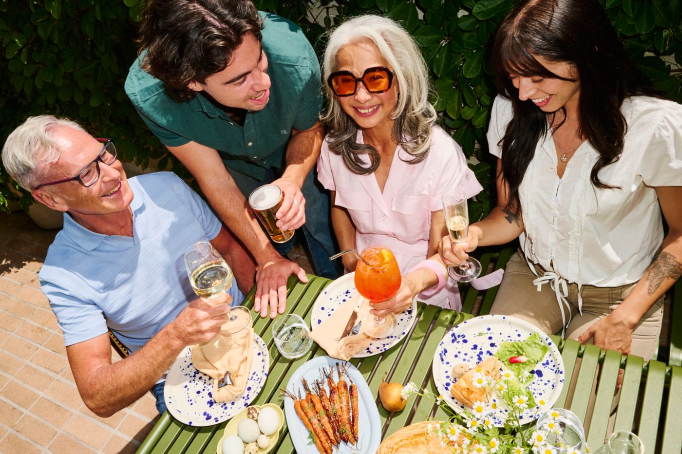 A table of people enjoying drinks and food 