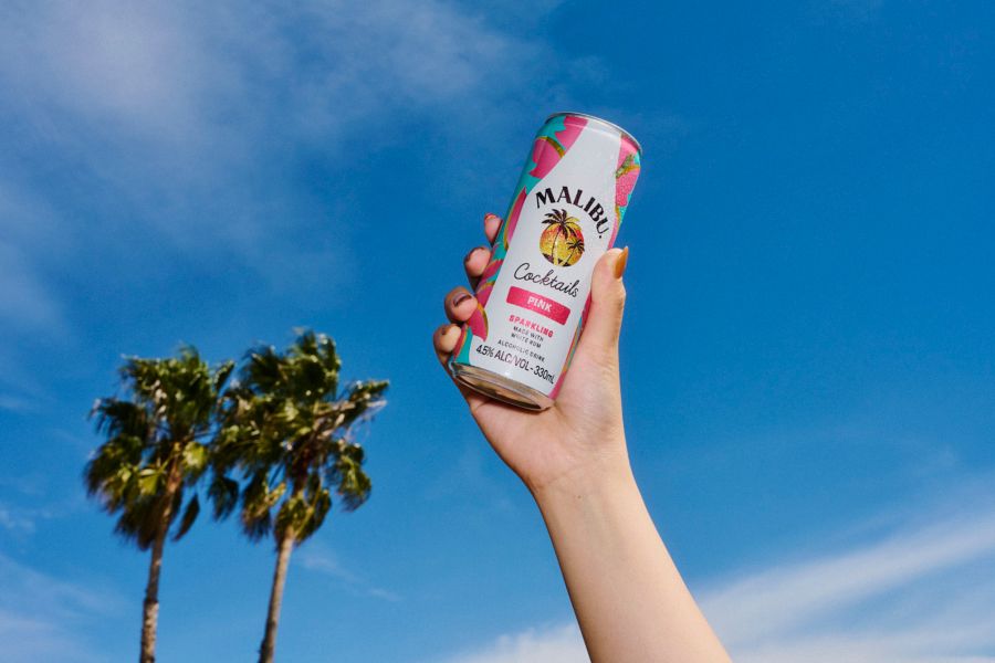 Holding a can of the Malibu Pink against a blue-sky background