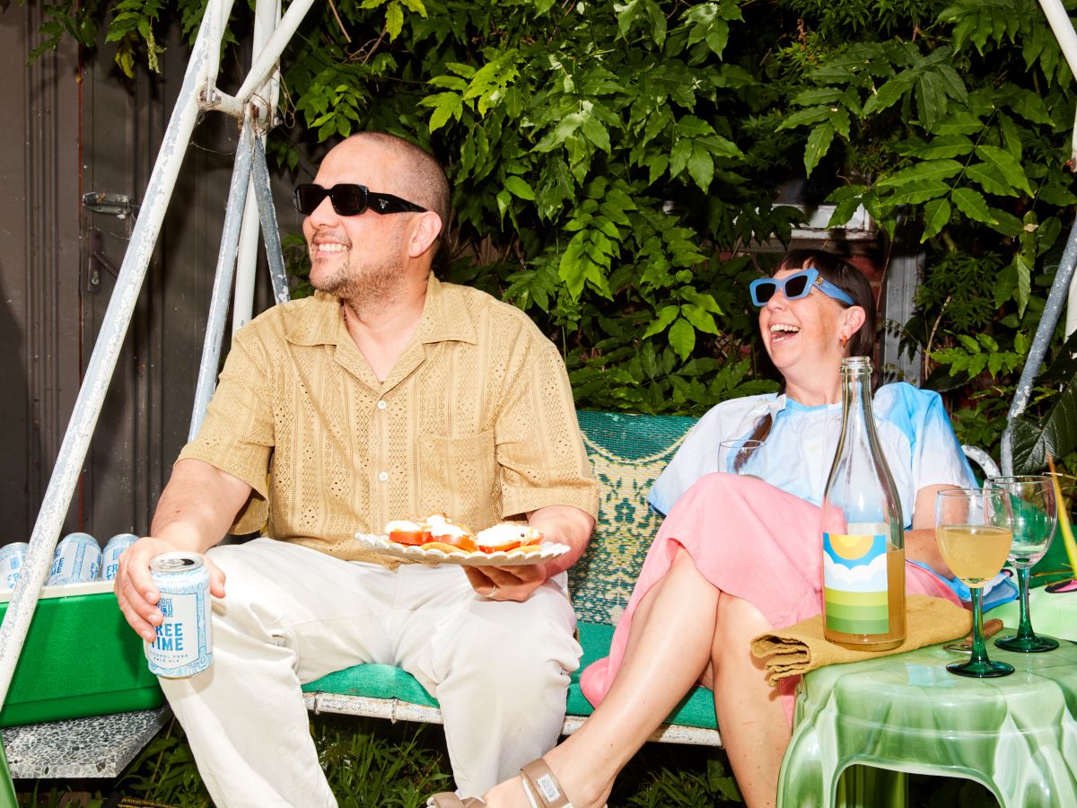Beci and Raph sitting in swing seat eating and drinking