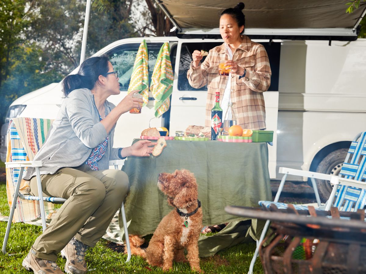 Thi and JY drinking and eating at the campsite
