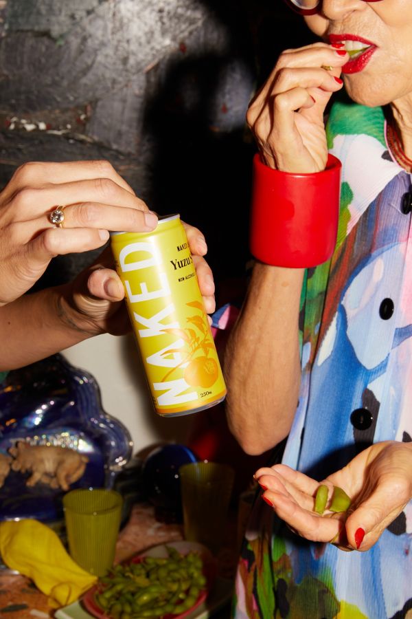 Grace opening a Naked Life Yuzu Sake non-alcoholic can and Jenny eating edamame