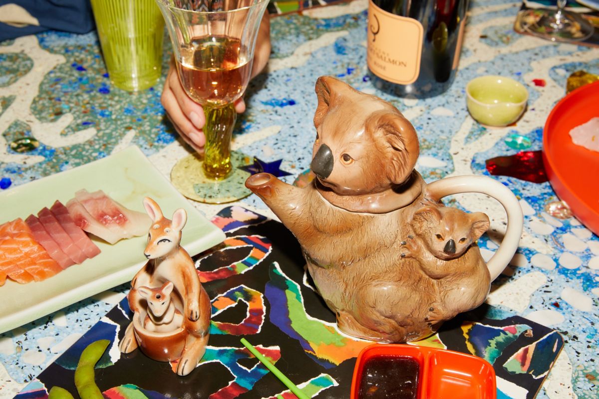 Australiana koala teapot on the dining table with sashimi and sparkling rosé