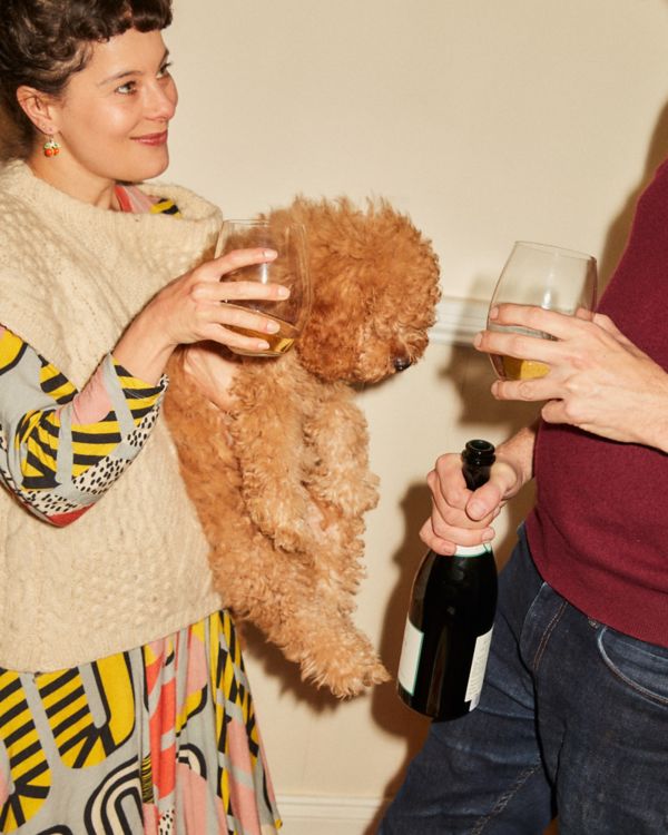 Helena holding puppy and glass of Champagne 