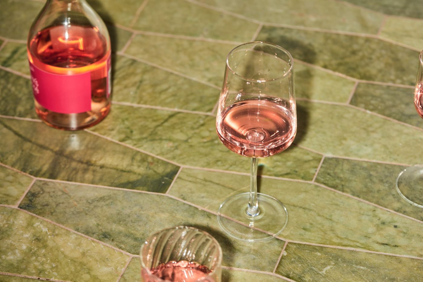 Glasses of rosé wine on green tiles