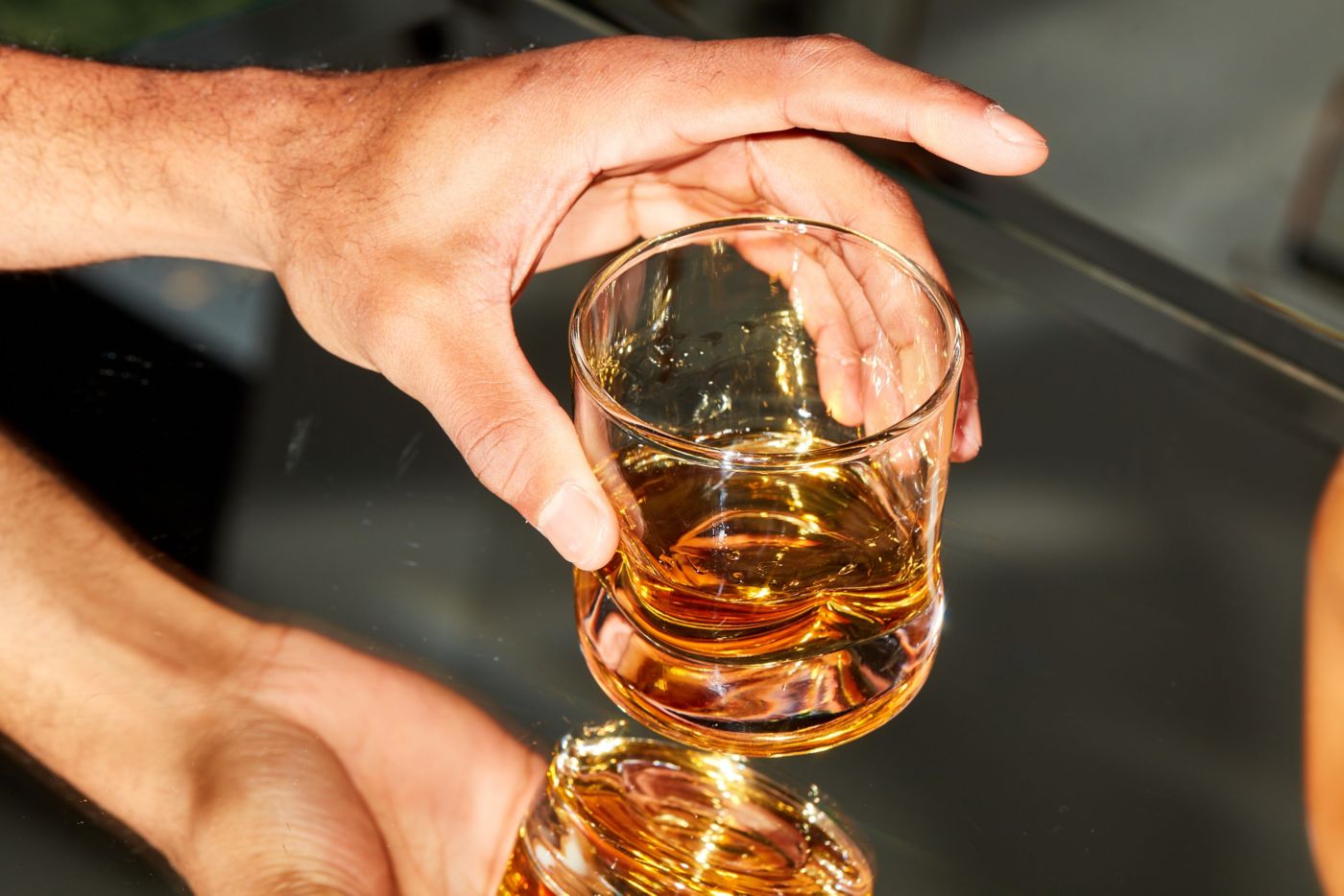 Holding a glass with a dram of whisky 