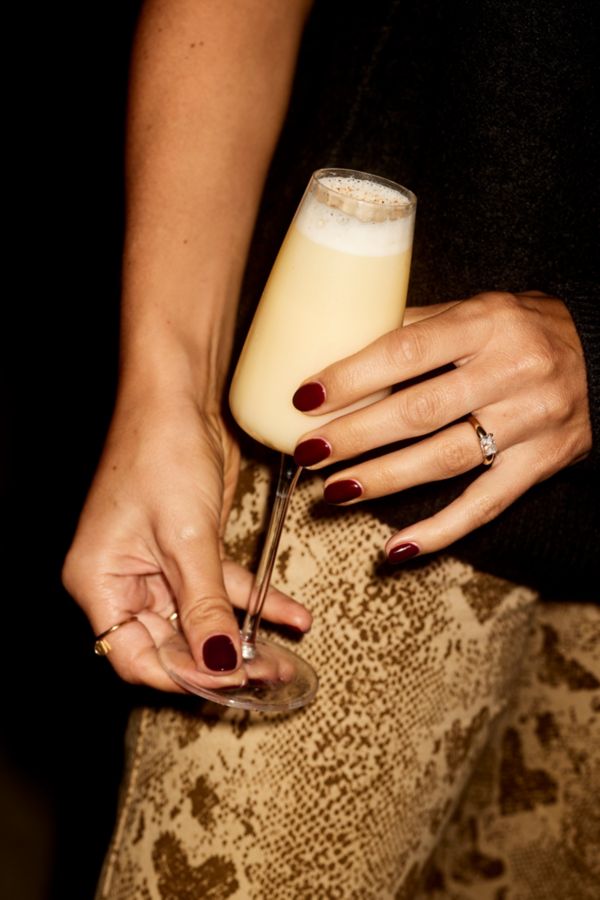 Holding the Snowball cocktail in a flute glass 