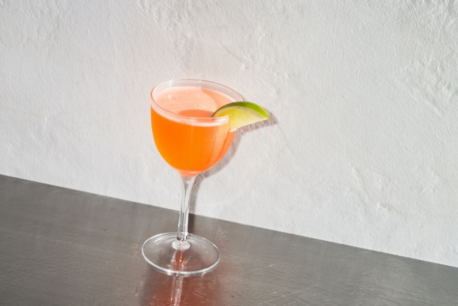 The Naked and Famous cocktail garnished with a lime wedge