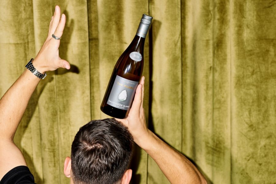 Holding a bottle of the Pebble Loire Sauvignon Blanc