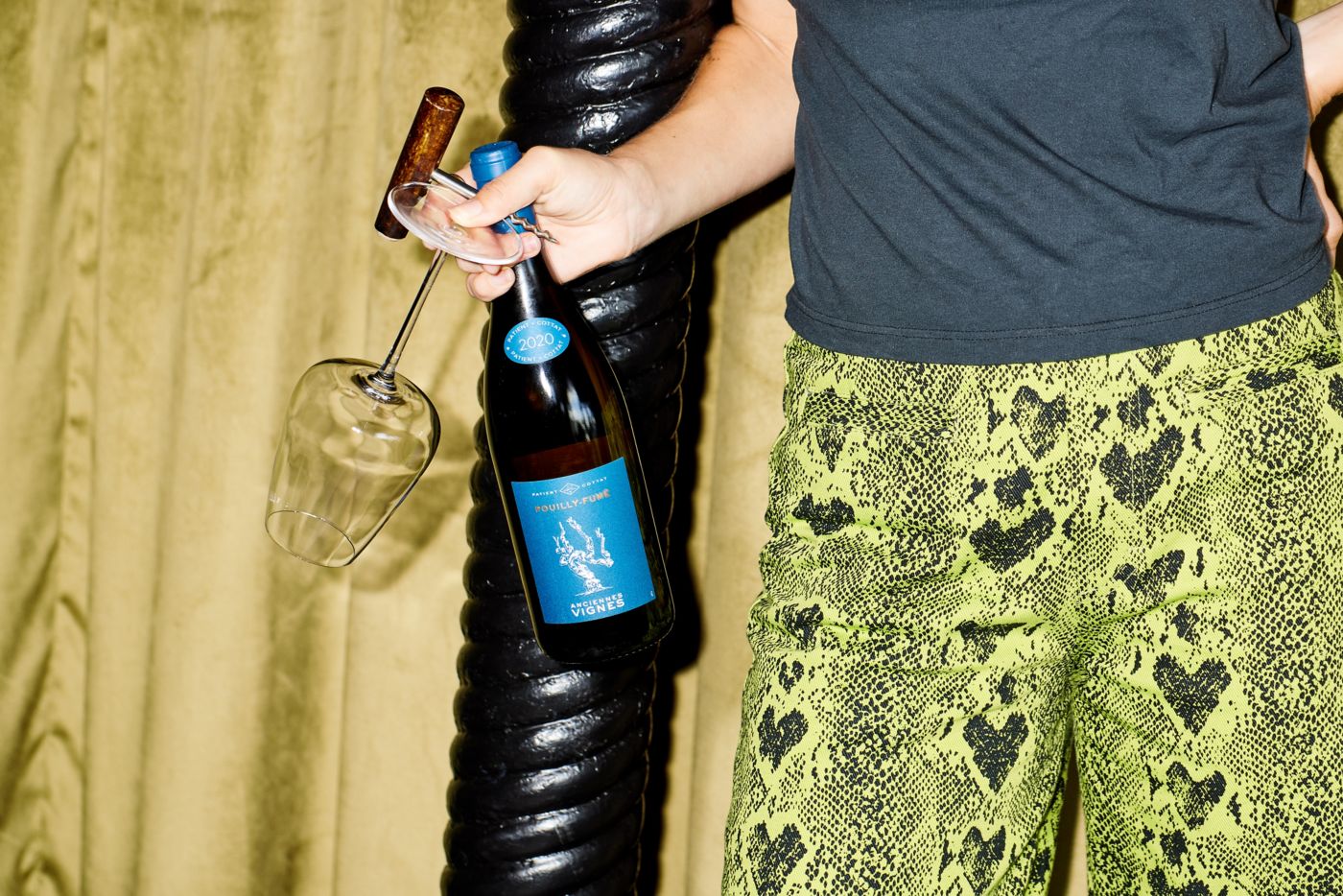 An image of a hand pouring white wine in the wine glass