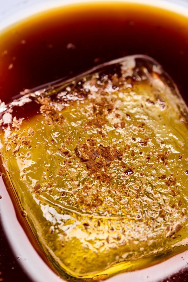 Looking down on a large block of ice with grated coffee beans