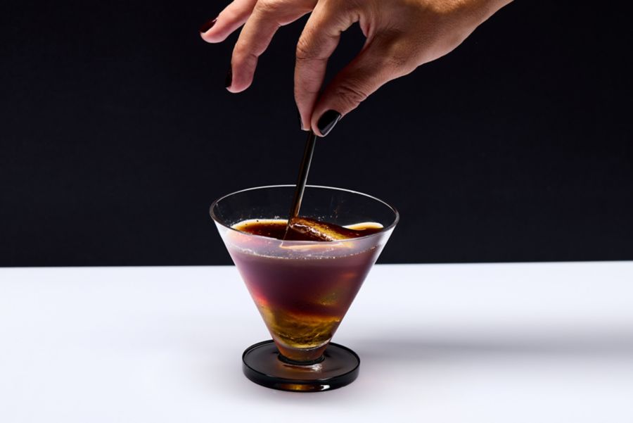 Stirring a Carajillo cocktail, made of coffee and Licor 43