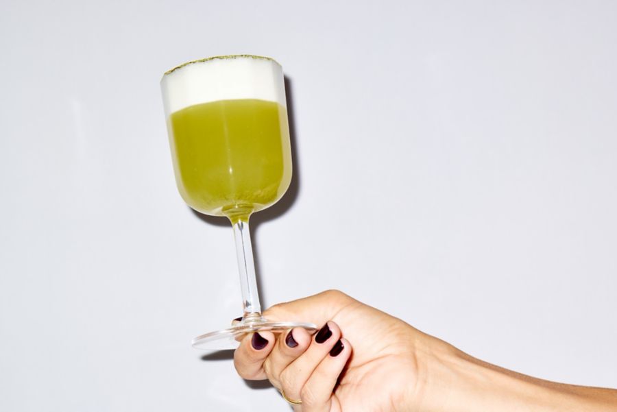 Holding a Matcha Fizz cocktail