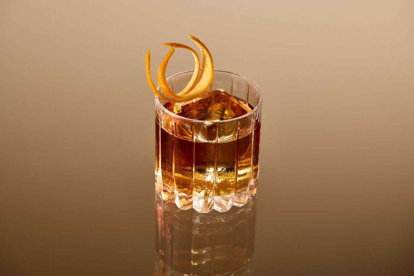 The bittersweet cocktail Remember The Alimony is garnished with an orange twist