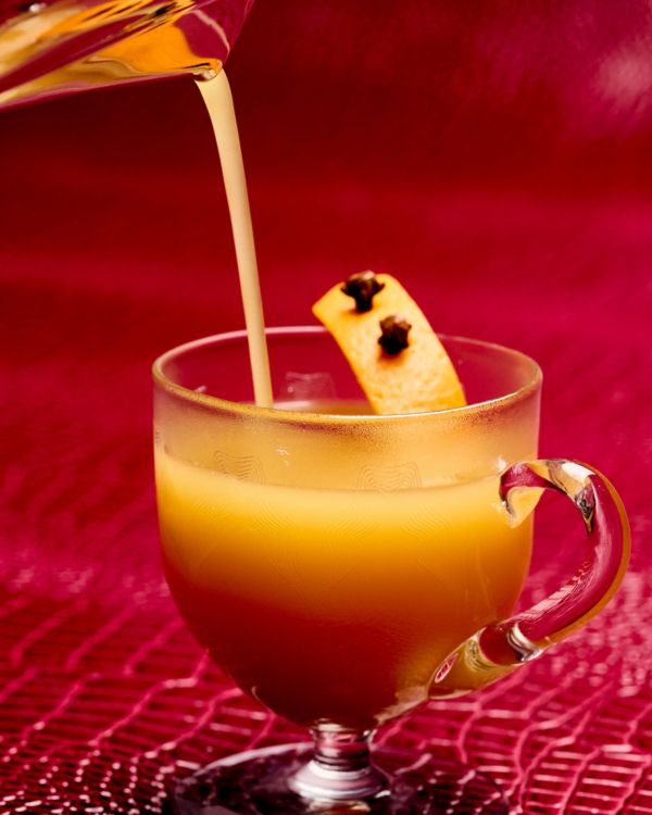 Pouring the warm Hot Buttered Rum cocktail into a glass