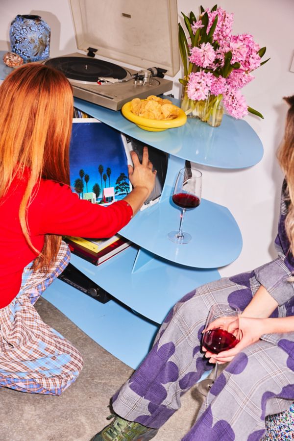 Choosing a record with a glass of red wine on the shelf