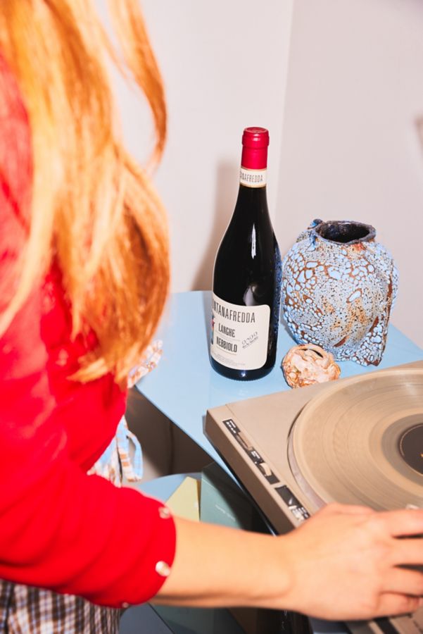 At the record player with a bottle of nebbiolo
