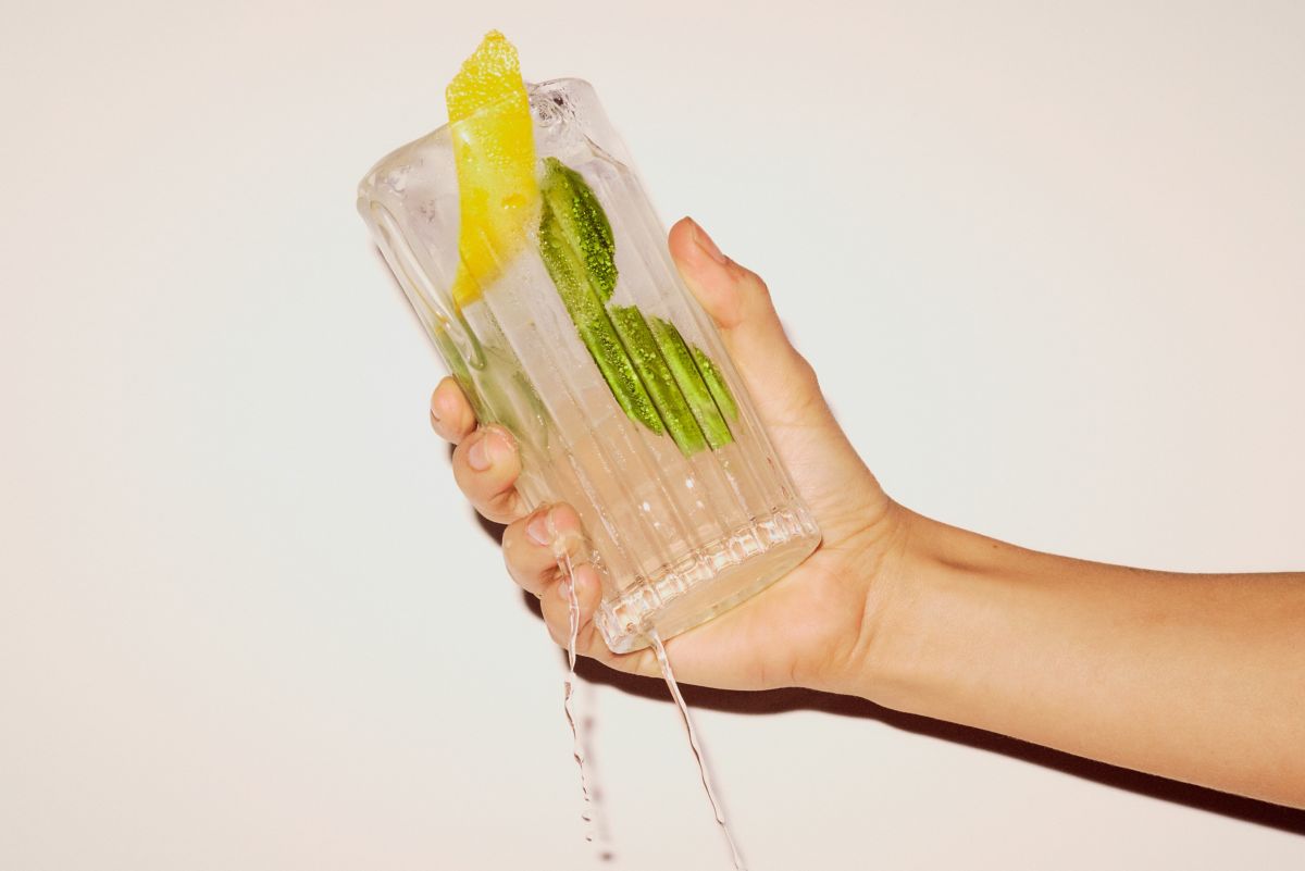 Holding a tall glass with the Amalfitano cocktail