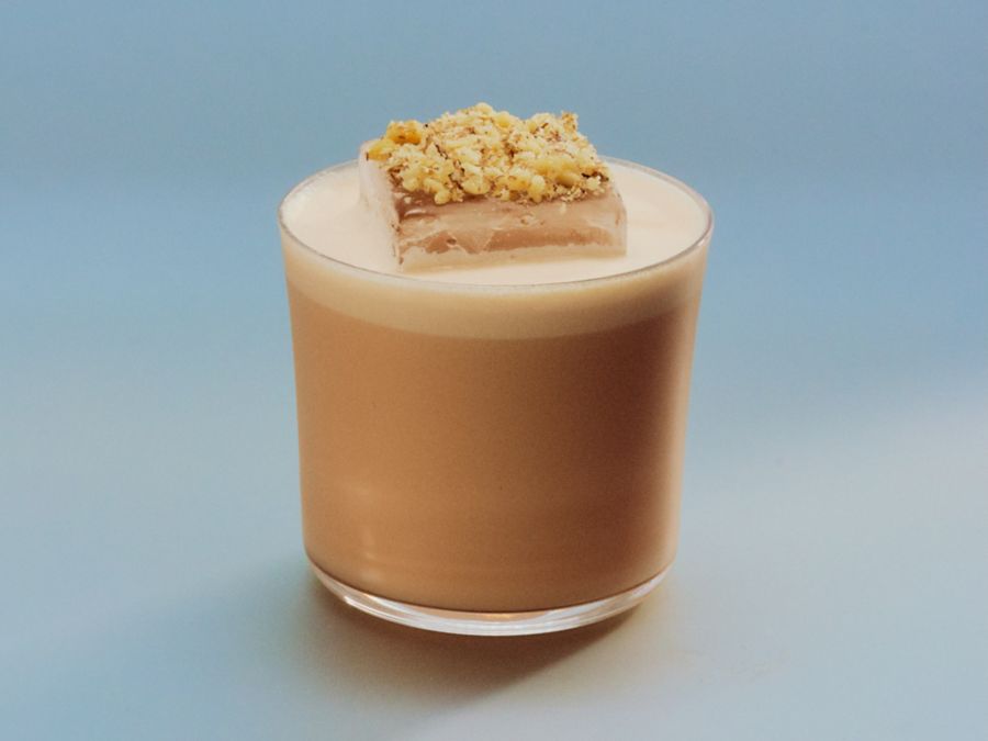 The Carrot Cake cocktail is garnished with crushed walnuts on top of the ice