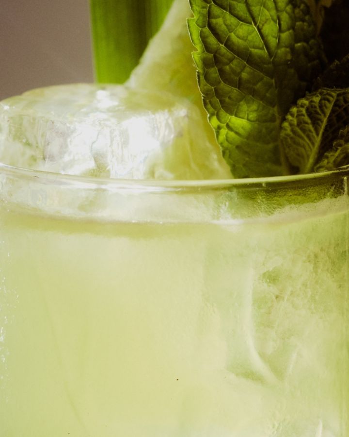 Mint, lime and pandan leaf garnish the Pandan Peach Fizz cocktail