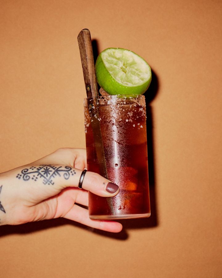 Batanga cocktail garnished with lime wedge and salt flakes on rim