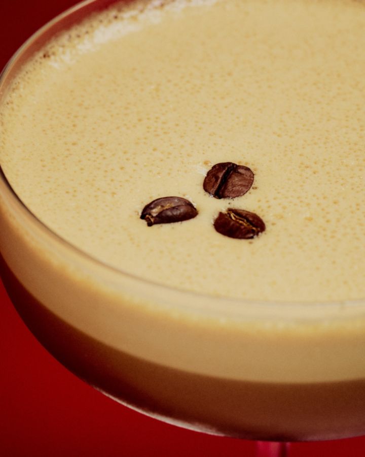 Close-up of an Espresso Martini topped with coffee beans on creamy foam
