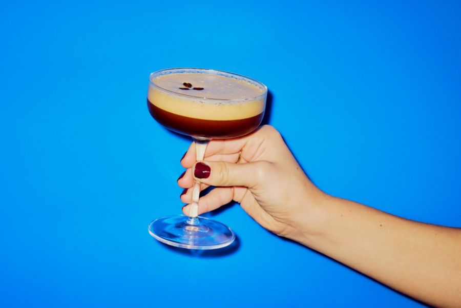 Holding a classic Espresso Martini cocktail  