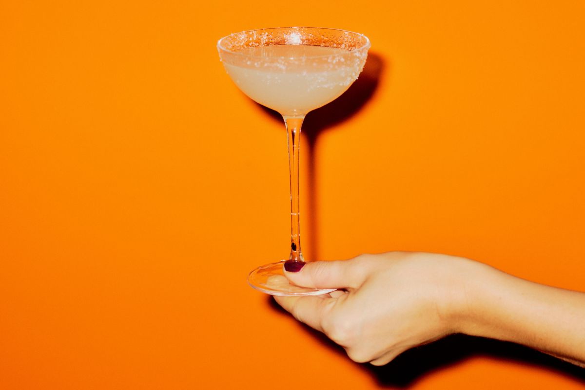 A Margarita with lime wedges next to it