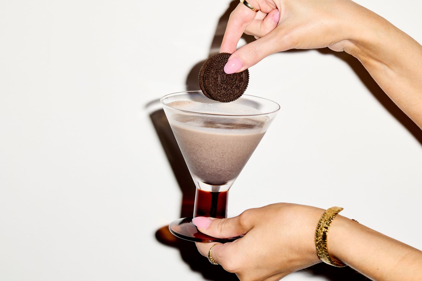 Dipping an Oreo cookie into the Cookies & Cream cocktail 