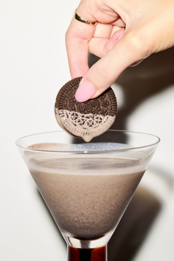 An Oreo cookie getting dipped into the Cookies & Cream cocktail