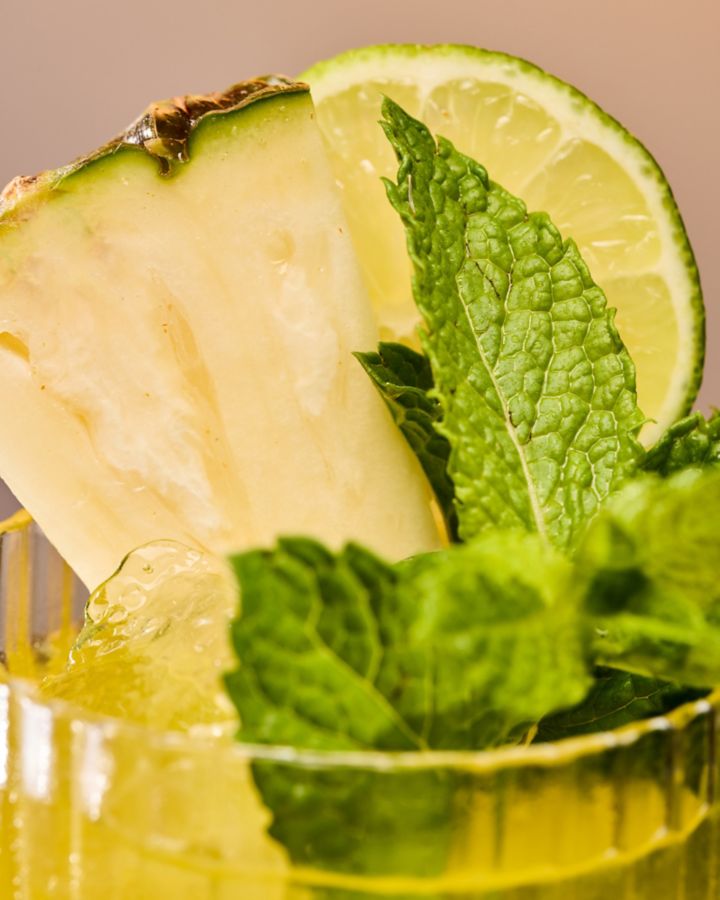A pineapple wedge, lime wheel and mint finish this tropical, refreshing cocktail 