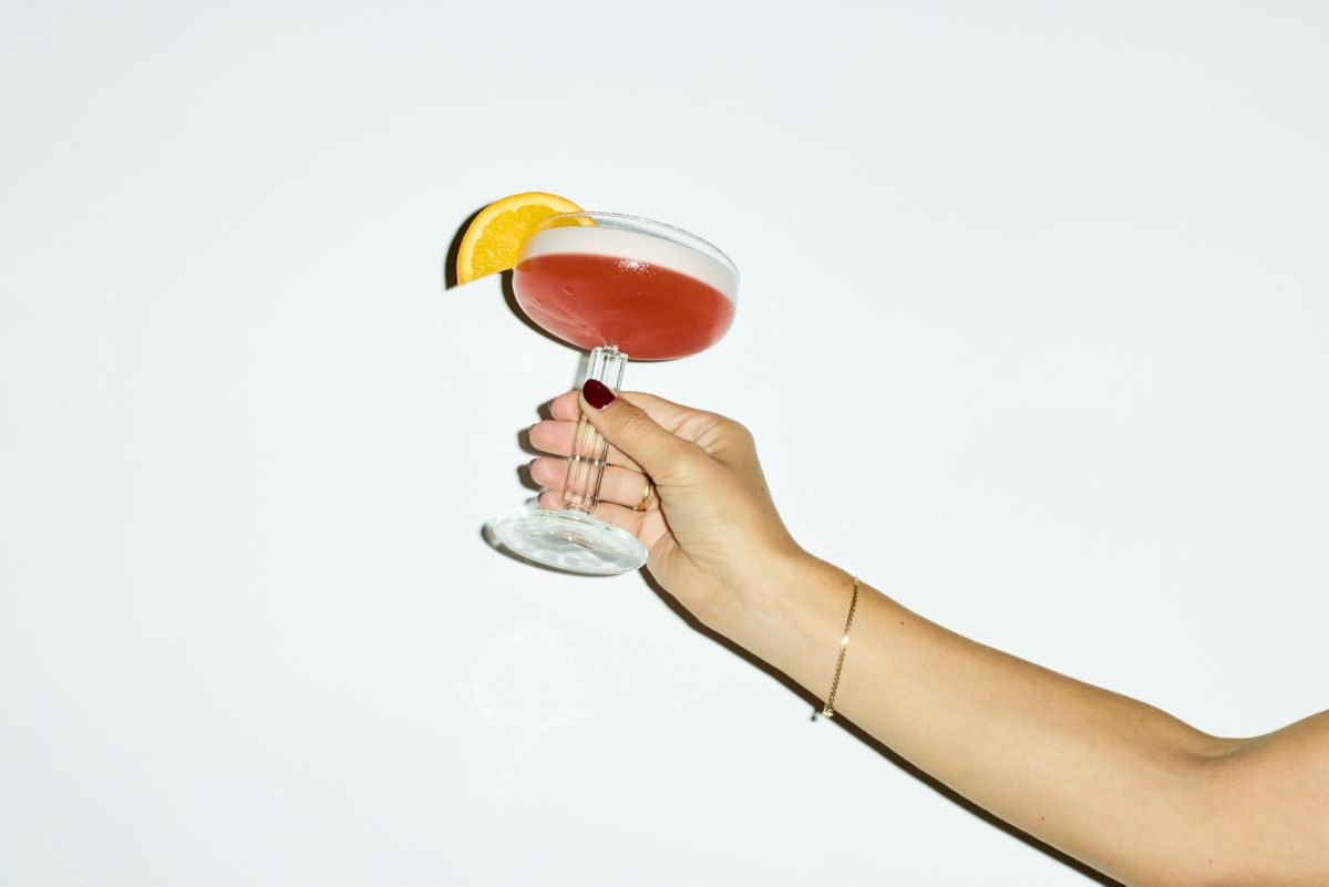 Holding a coupe glass with the Negroni Sour