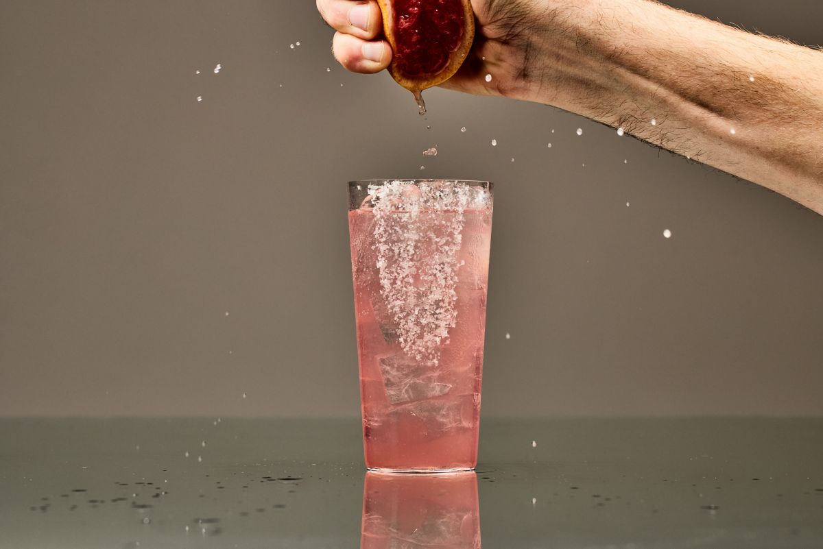 Squeezing a grapefruit into a Paloma cocktail