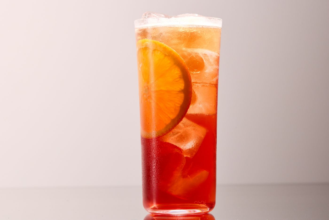The brigh orange Campari IPA Spritz cocktail in a tall glass 