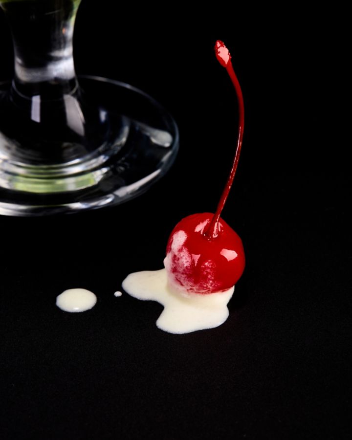 A close-up of the cherry garnish on the table 